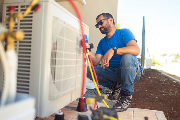 Technician servicing outdoor AC units on a building wall
