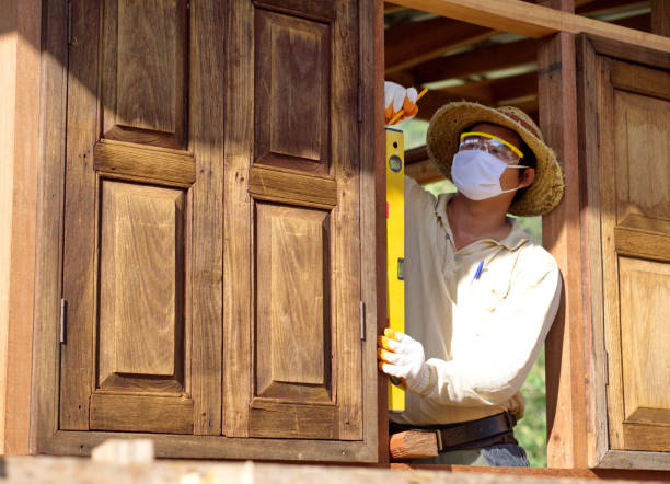 Carpenter shaping wooden frames in a workshop
